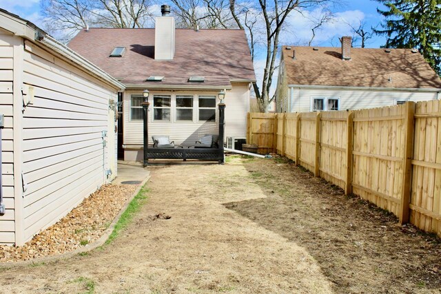 back of house featuring a chimney and a fenced backyard
