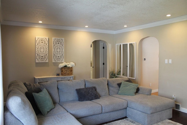 living area with arched walkways, baseboards, and a textured ceiling