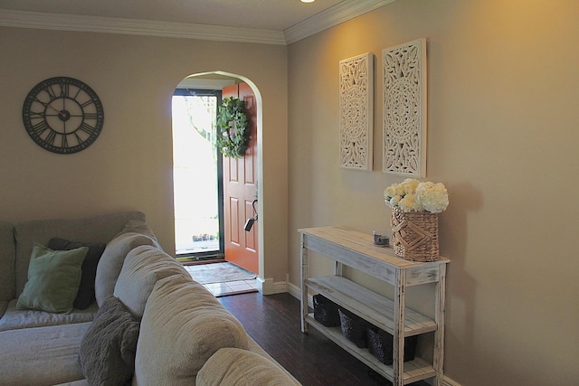 foyer entrance featuring ornamental molding, arched walkways, dark wood-style floors, and baseboards