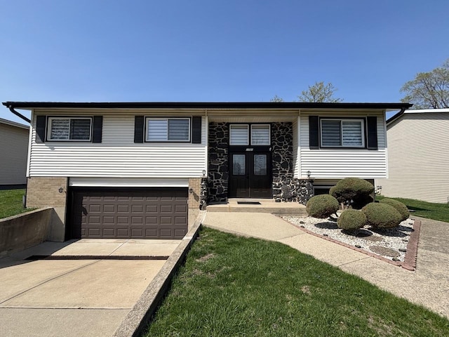 view of front of house with concrete driveway, french doors, brick siding, and a garage