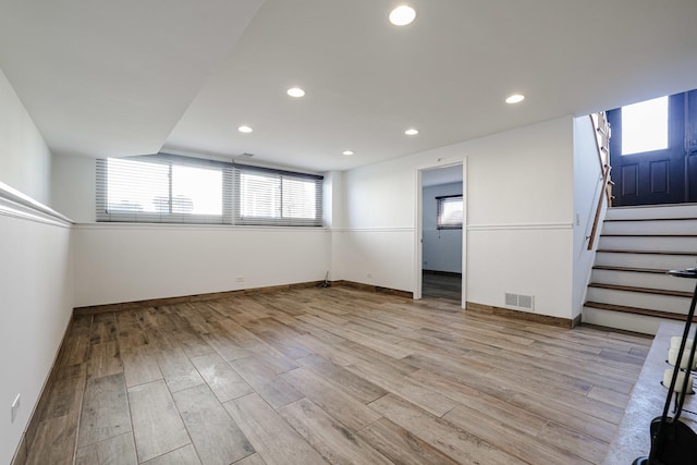 below grade area with visible vents, light wood-style floors, stairway, and recessed lighting