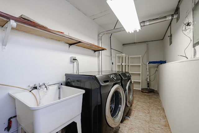 clothes washing area with washer and dryer, a sink, a garage, and laundry area