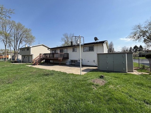 rear view of house with a wooden deck, stairway, a patio area, a lawn, and fence