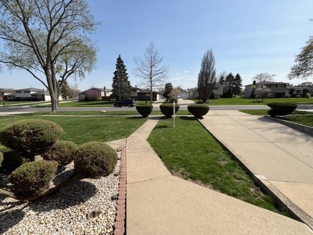 view of community with a residential view and a yard