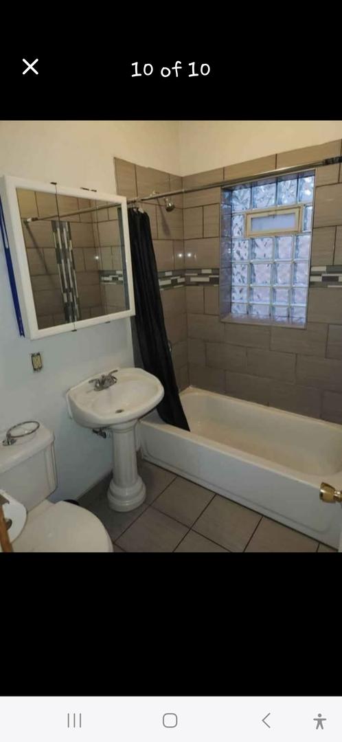 bathroom with toilet, tile patterned flooring, and shower / bath combo with shower curtain