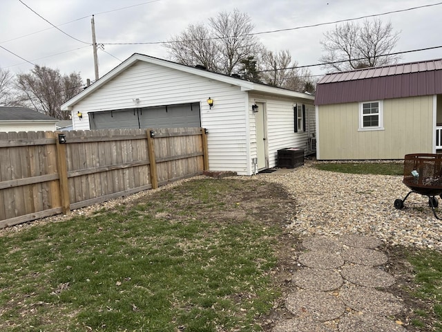 view of yard with fence, an outbuilding, and a garage