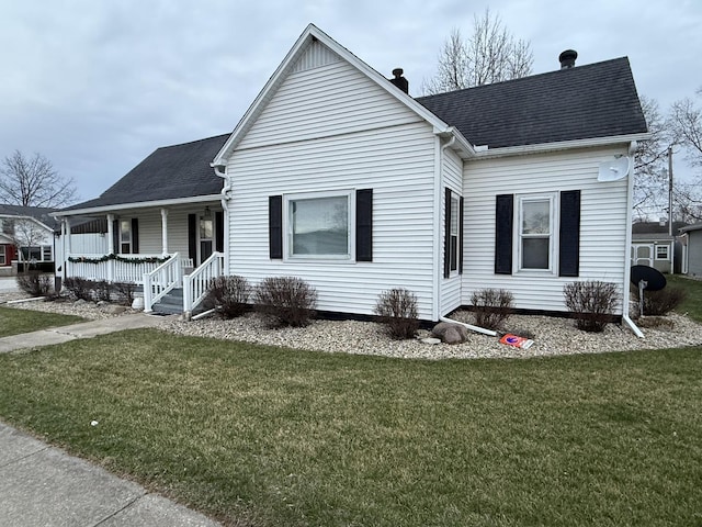 view of front of home featuring a porch, roof with shingles, and a front lawn