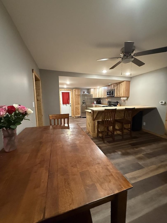 dining area featuring dark wood-style flooring and ceiling fan