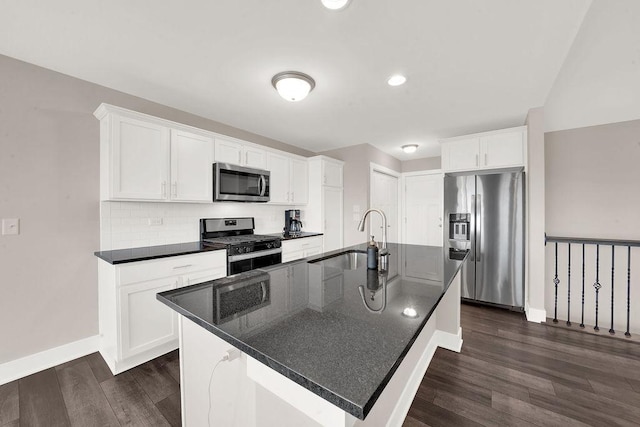 kitchen featuring stainless steel appliances, dark wood-type flooring, decorative backsplash, a sink, and white cabinets