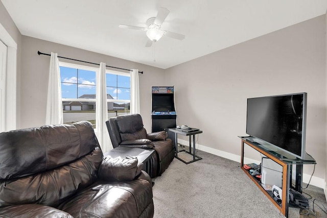 carpeted living room with baseboards and a ceiling fan