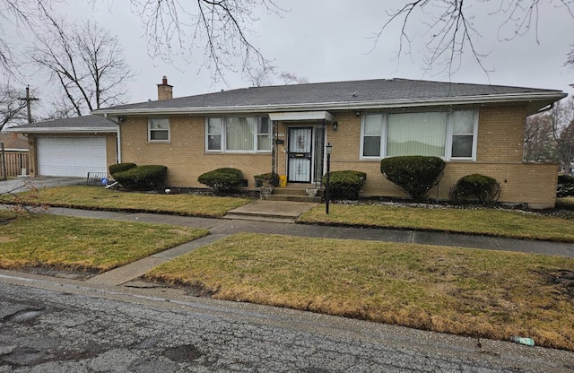 view of front of property with a chimney, a garage, concrete driveway, brick siding, and a front lawn