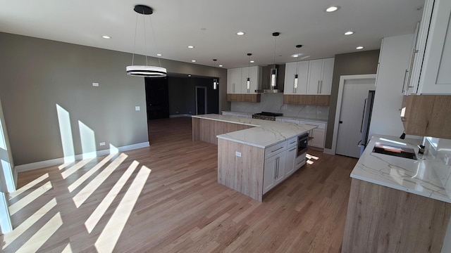 kitchen featuring decorative backsplash, range, a large island, light wood-style flooring, and ventilation hood
