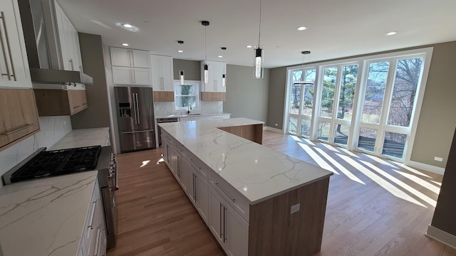 kitchen with wood finished floors, cooktop, a center island, high quality fridge, and backsplash