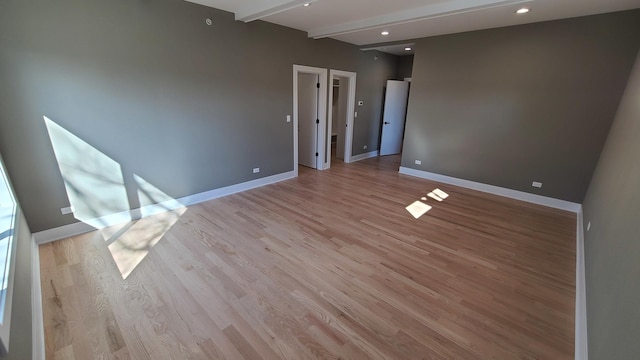 unfurnished room featuring light wood finished floors, baseboards, beam ceiling, and recessed lighting