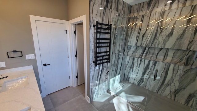 bathroom with a marble finish shower and vanity