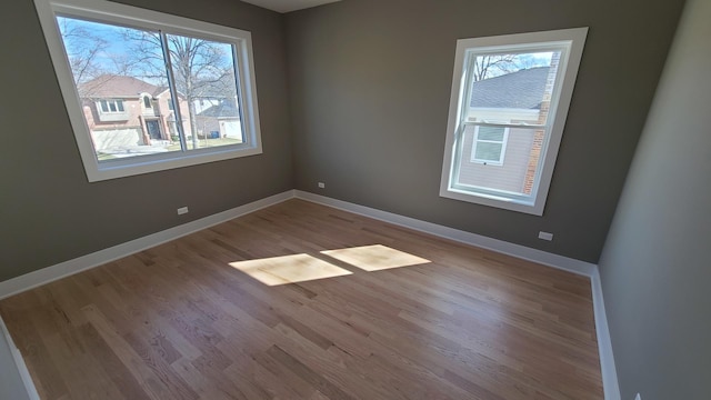 empty room with baseboards and wood finished floors