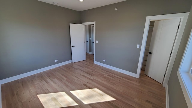 unfurnished bedroom with recessed lighting, baseboards, and light wood-type flooring