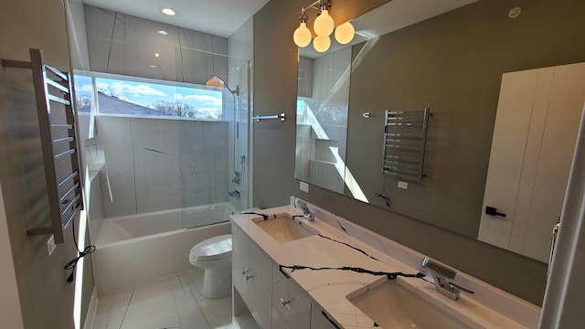 bathroom with double vanity, toilet, bathtub / shower combination, and a sink