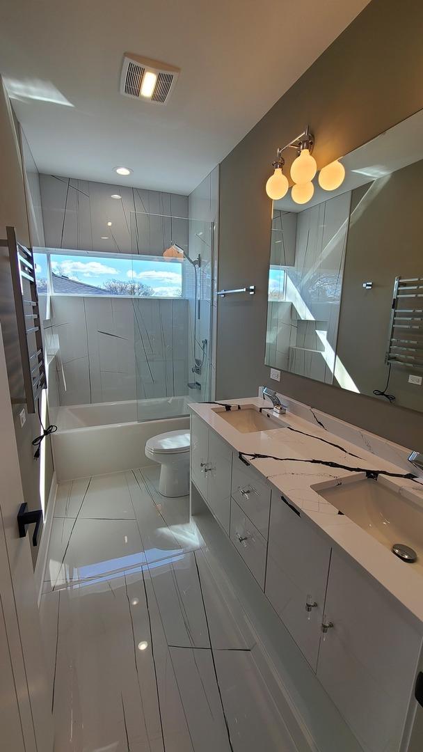 full bath featuring toilet, a sink, shower / washtub combination, and visible vents