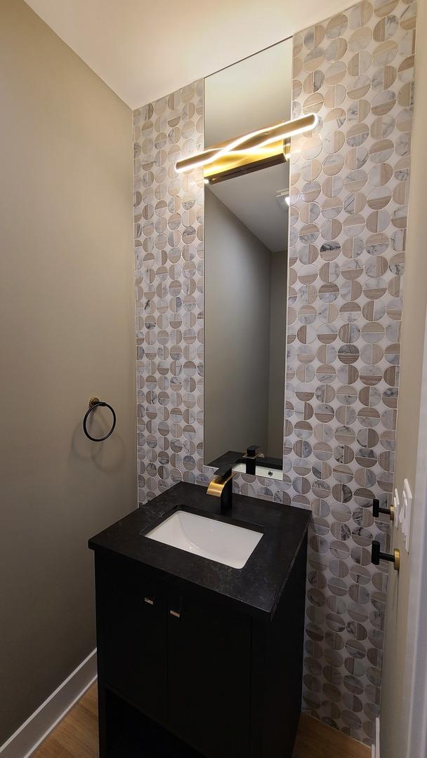 bathroom featuring baseboards, wood finished floors, and vanity
