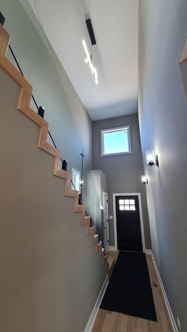 entrance foyer featuring baseboards, stairway, and wood finished floors