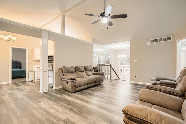 living room featuring baseboards, visible vents, light wood-style floors, and ceiling fan with notable chandelier