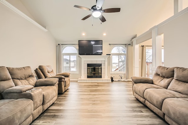 living room featuring a tiled fireplace, wood finished floors, lofted ceiling, ceiling fan, and recessed lighting