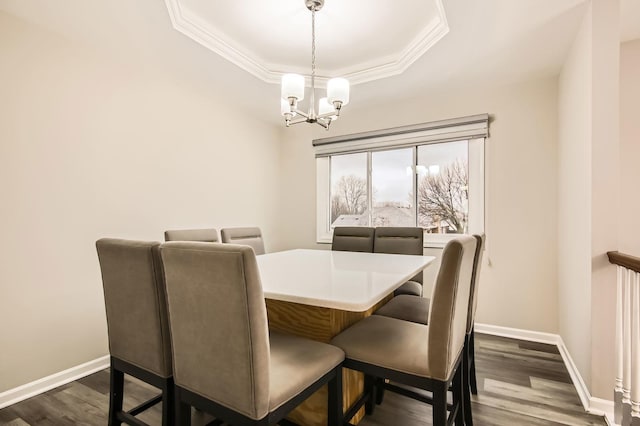 dining area with a tray ceiling, a notable chandelier, crown molding, baseboards, and dark wood-type flooring