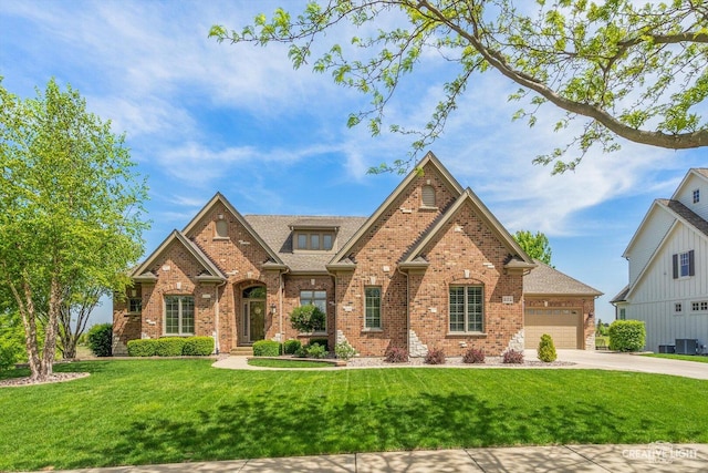 974 Chestnut Hill Ln, Sugar Grove, IL 60554 - view of front of house with brick siding, concrete driveway, a front yard, a garage, and central AC unit