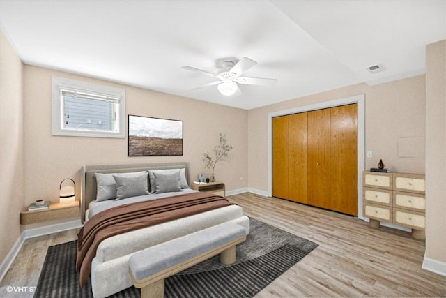 bedroom featuring light wood-style floors, baseboards, a closet, and a ceiling fan