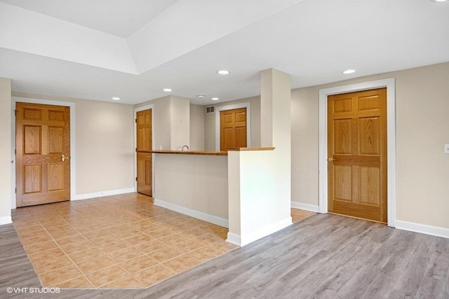 empty room featuring baseboards, recessed lighting, and light wood finished floors