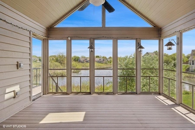 unfurnished sunroom featuring lofted ceiling, a ceiling fan, a deck with water view, wooden ceiling, and hardwood / wood-style floors