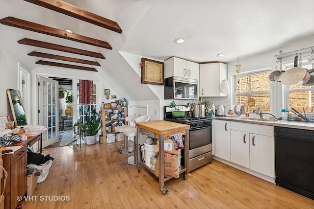 1943 N Whipple St, Chicago, IL 60647 - kitchen featuring appliances with stainless steel finishes, white cabinets, light wood-style floors, and recessed lighting