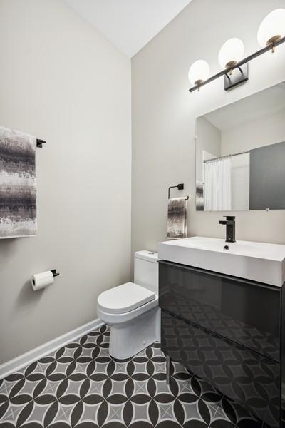 1540 E 65th Pl Unit 3, Chicago, IL 60637 - full bathroom with baseboards, toilet, vaulted ceiling, and vanity