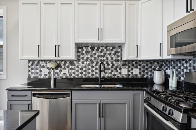 1540 E 65th Pl Unit 3, Chicago, IL 60637 - kitchen with white cabinets, dark stone counters, appliances with stainless steel finishes, a sink, and backsplash