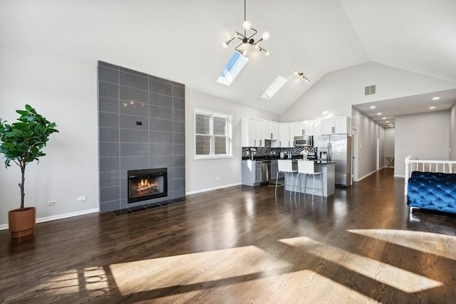 1540 E 65th Pl Unit 3, Chicago, IL 60637 - living room with dark wood-style flooring, a tile fireplace, baseboards, and visible vents
