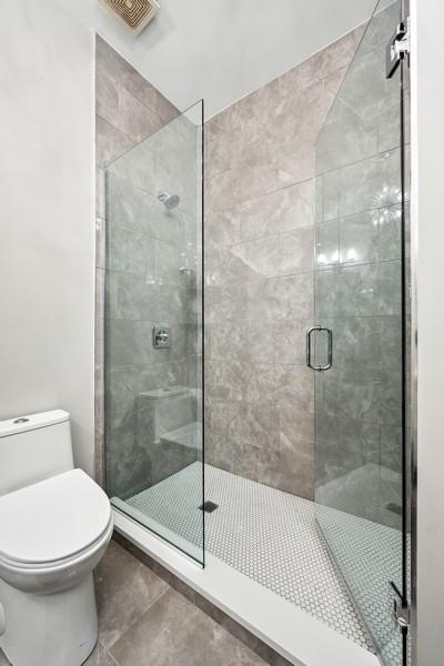 1540 E 65th Pl Unit 3, Chicago, IL 60637 - bathroom featuring toilet, a stall shower, tile patterned flooring, and visible vents