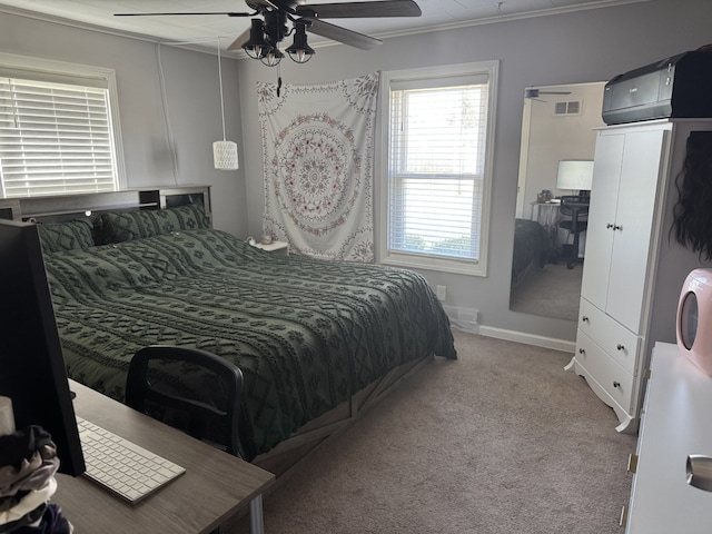 bedroom featuring crown molding, carpet flooring, baseboards, ceiling fan, and visible vents