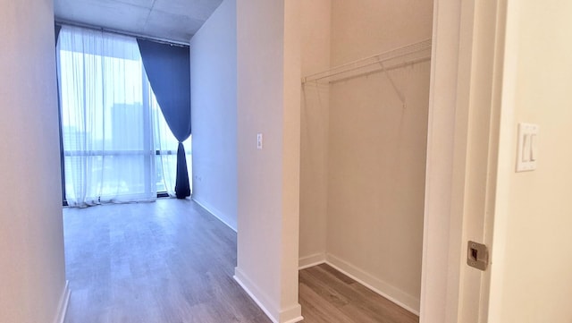 hall featuring baseboards and wood finished floors