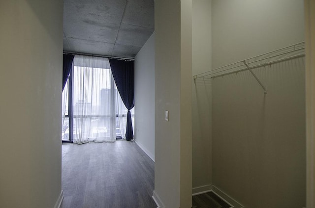 corridor featuring dark wood-style floors and baseboards