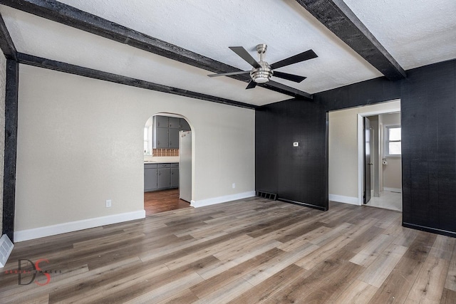 161 S Cash St, Seneca, IL 61360 - spare room with arched walkways, beamed ceiling, visible vents, a ceiling fan, and wood finished floors