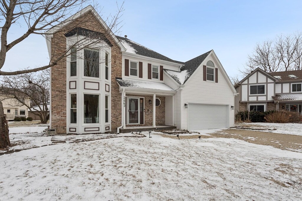 view of front facade with a garage and brick siding