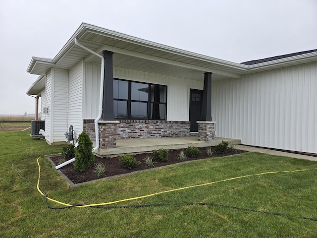 2477 Stanfield Ln, Normal, IL 61761 - property entrance with a porch, brick siding, a lawn, and central AC