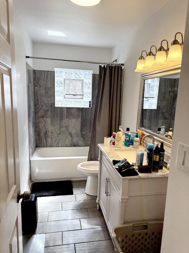 full bathroom featuring wood finish floors, toilet, vanity, and shower / bath combo with shower curtain