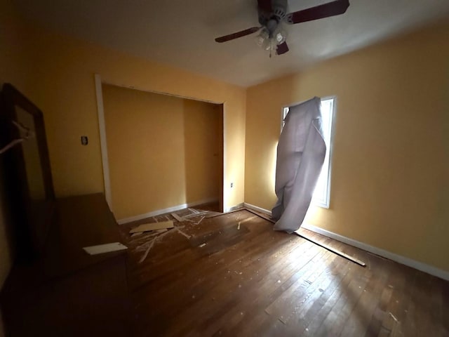 unfurnished bedroom featuring multiple windows, hardwood / wood-style flooring, and baseboards