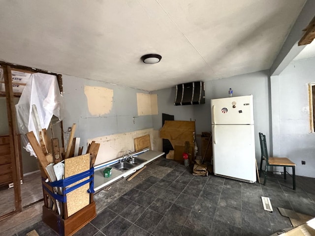 kitchen with a sink and freestanding refrigerator