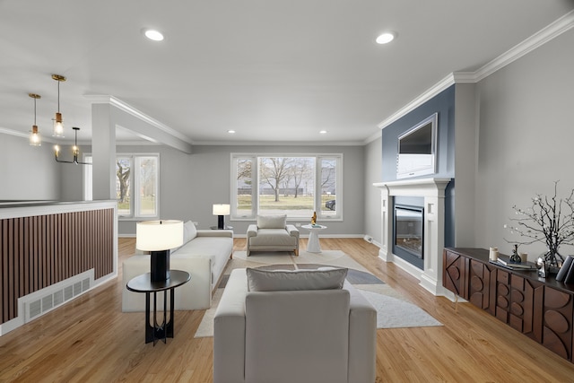 living room with light wood-style flooring, plenty of natural light, and ornamental molding