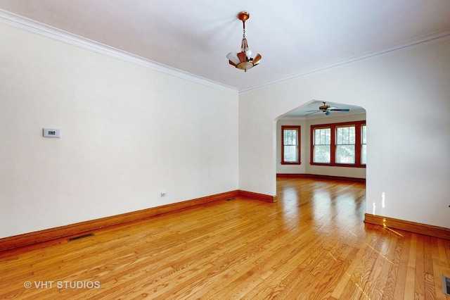 3028 N Kostner Ave, Chicago, IL 60641 - empty room with crown molding, light wood-style flooring, baseboards, arched walkways, and a ceiling fan