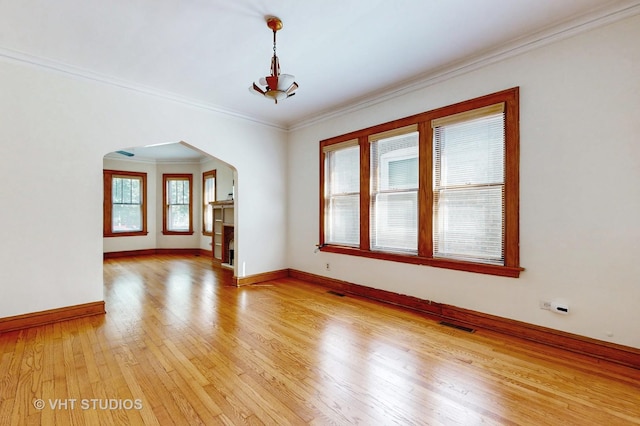 3028 N Kostner Ave, Chicago, IL 60641 - unfurnished room featuring ornamental molding, baseboards, arched walkways, visible vents, and light wood-style flooring