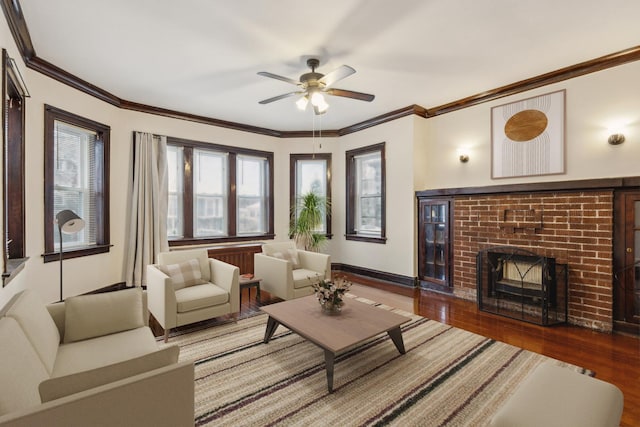 living area with baseboards, wood finished floors, ornamental molding, and a ceiling fan